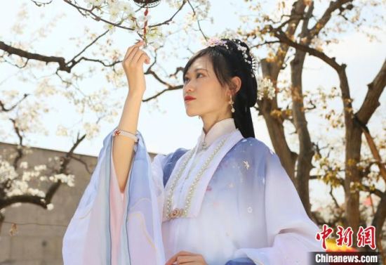圖為蘭州青年身穿漢服在百年梨園賞景?！「哒?攝