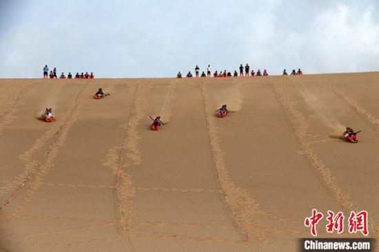 6月13日，敦煌鳴沙山月牙泉景區(qū)舉辦滑沙比賽。　張曉亮 攝