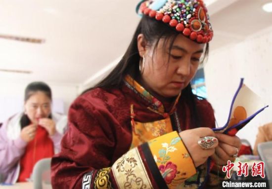 圖為裕固族婦女學(xué)習(xí)刺繡?！∈缝o靜 攝