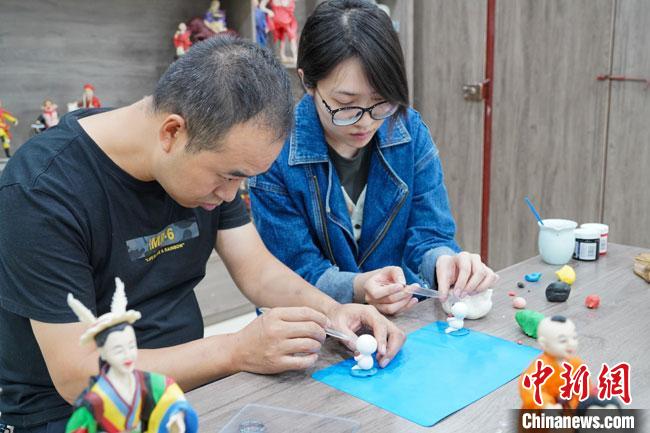 <a target='_blank'  data-cke-saved- >中新社</a>記者(右)現(xiàn)場體驗面塑制作過程?！￡悹帍?攝