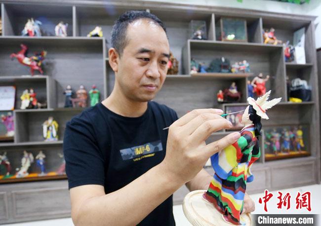 圖為安秋平正在創(chuàng)作代表隴南文縣民俗的《白馬人》作品。　高展 攝