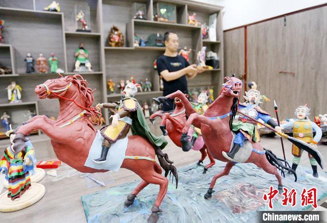 安秋平是成州面塑第五代傳承人，也是當?shù)匚ㄒ粓允孛嫠苤谱鞯娜??！「哒?攝