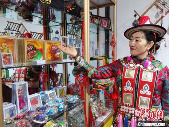 圖為身著民族服飾的隴原巧手展示手工藝品。(資料圖) 徐雪 攝