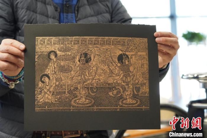 圖為手工書藝人展示敦煌雕版壁畫印刷品?！【琶赖┰?　攝
