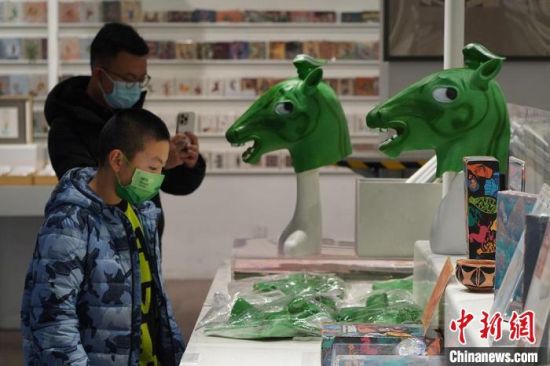 圖為“神馬來了”銅奔馬頭套吸引參觀者駐足?！【琶赖┰?攝