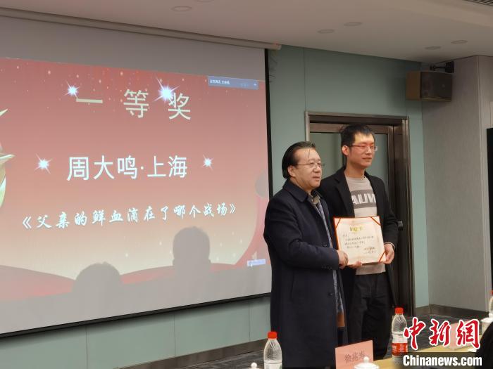 圖為作家、西北師范大學新聞與傳媒學院院長徐兆壽頒發(fā)一等獎證書，代領(lǐng)獎?wù)呱吓_領(lǐng)獎?！钅?攝