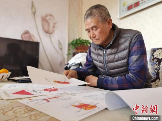 圖為陸鵬飛向記者展示多年帶隊(duì)的手寫(xiě)筆記?！堟?攝