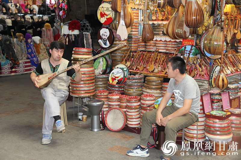 烏魯木齊二道橋巴扎內(nèi)，店主正在向客人展示樂器。楊文遠(yuǎn) 攝
