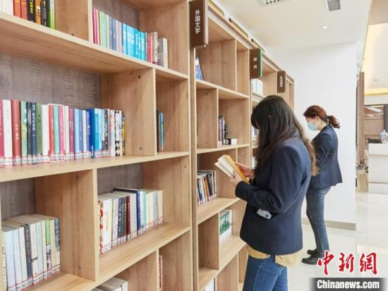 圖為在甘肅公航旅建設(shè)集團(tuán)有限公司的職工書屋，職工挑選書籍?！⌒煅?攝