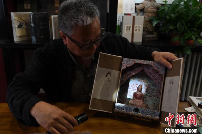 圖為讀者出版集團讀者晉林工作室獨立出品人徐晉林，展示互動性強的敦煌題材手工書。(資料圖) 楊艷敏 攝