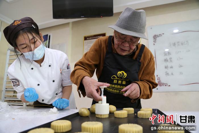當(dāng)日，受邀參加活動的臺胞臺屬代表、兩岸婚姻及子女、在甘臺商代表等歡聚一堂。圖為77歲的在甘臺胞潘天鑒制作月餅。九美旦增 攝