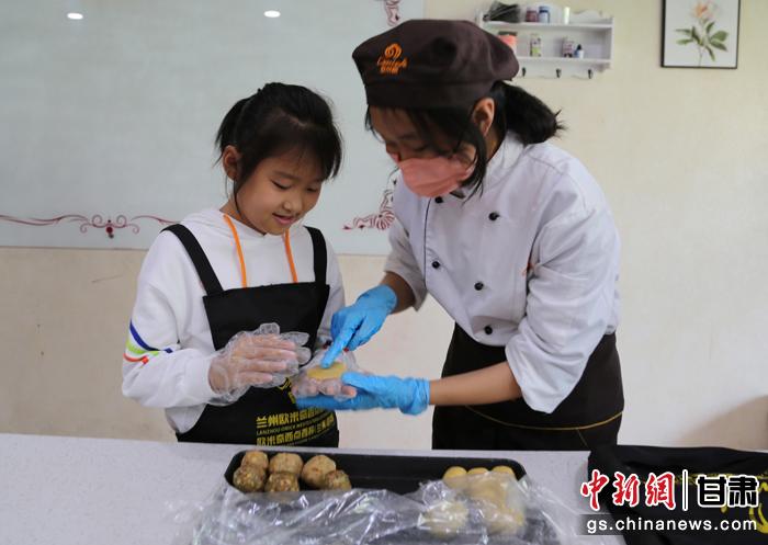 圖為在甘臺胞小朋友在工作人員指導(dǎo)下制作月餅。九美旦增 攝