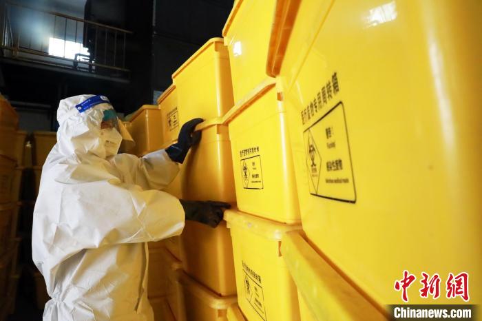 圖為工作人員搬運(yùn)醫(yī)療廢物專(zhuān)用周轉(zhuǎn)箱。　魏建軍 攝