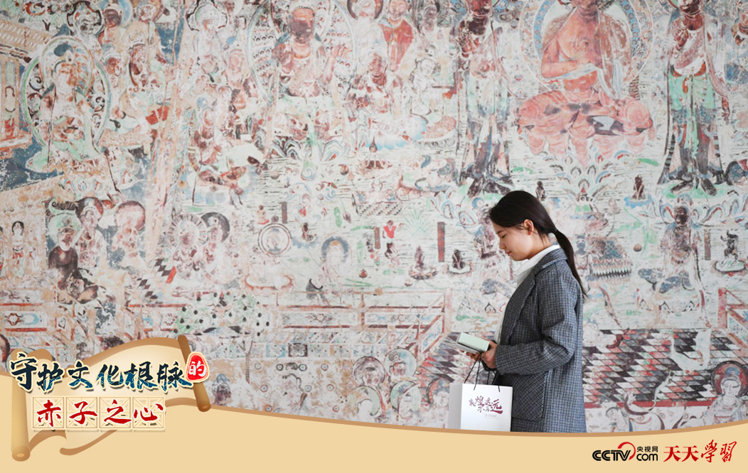 2023年4月25日，敦煌研究院文物數(shù)字化保護(hù)團(tuán)隊創(chuàng)意營銷人員廖雪婷從一幅高保真復(fù)制壁畫前走過。