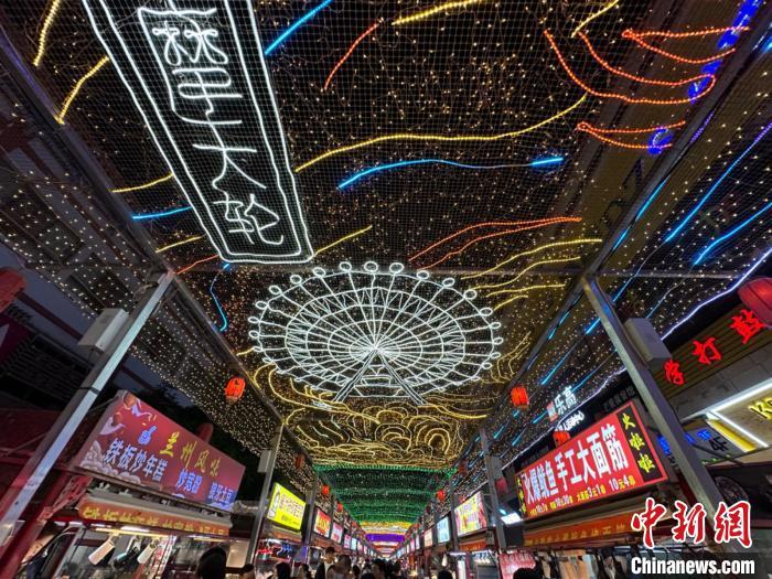 圖為明清街夜市燈光點(diǎn)亮具有武威文化元素的“摩天輪”彩燈?！〈魑牟?攝</p><p>