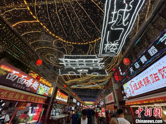 圖為明清街夜市燈光點(diǎn)亮具有武威文化元素的“涼州古城門”彩燈?！〈魑牟?攝</p><p>