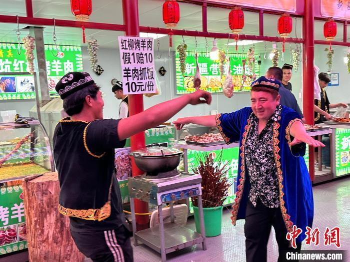 圖為餐飲經(jīng)營(yíng)者在“西涼不夜城”跳起舞蹈引客?！〈魑牟?攝</p><p>